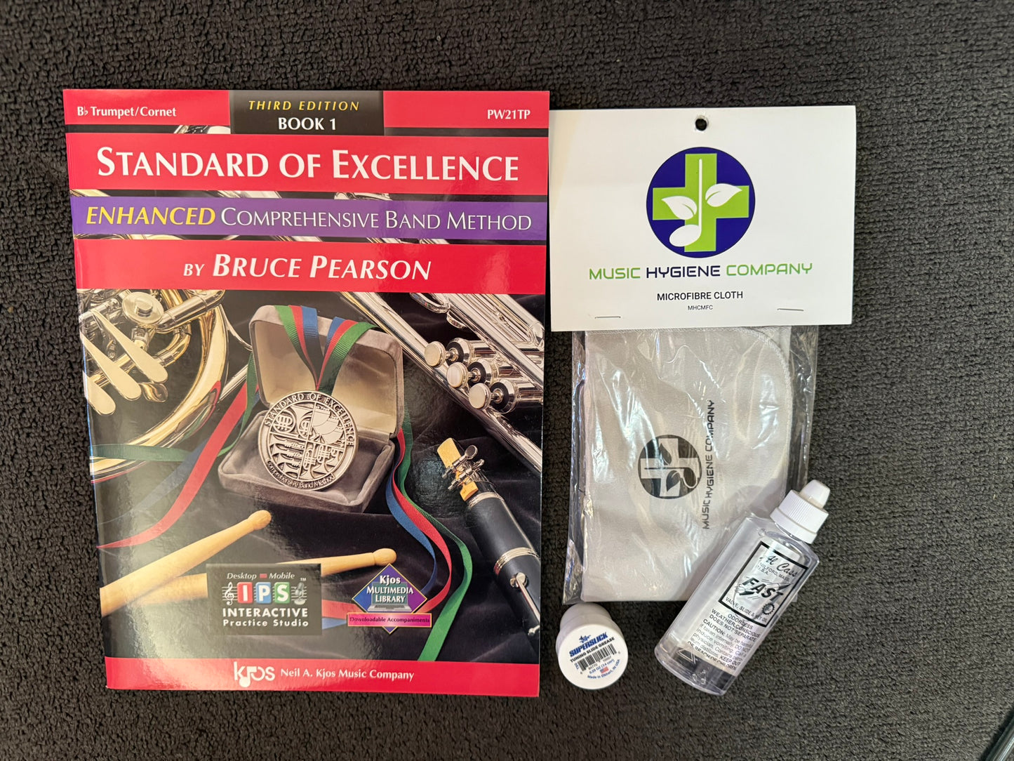 Trumpet method book, cleaning cloth, tuning slide grease, and valve oil.