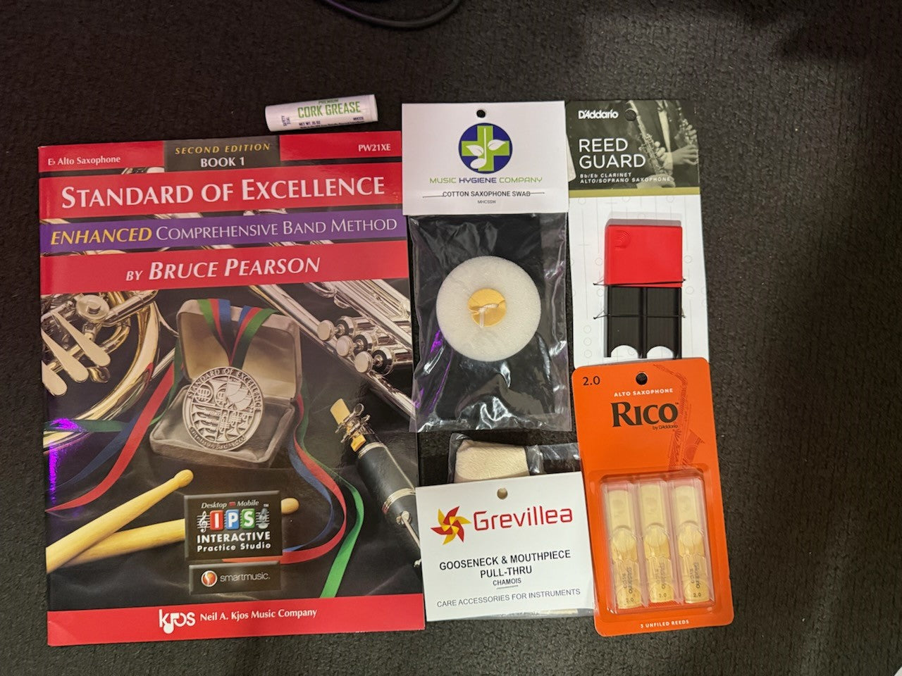 Alto saxophone student bundle with book, reeds, reed guard, grease, chamois, and swab.