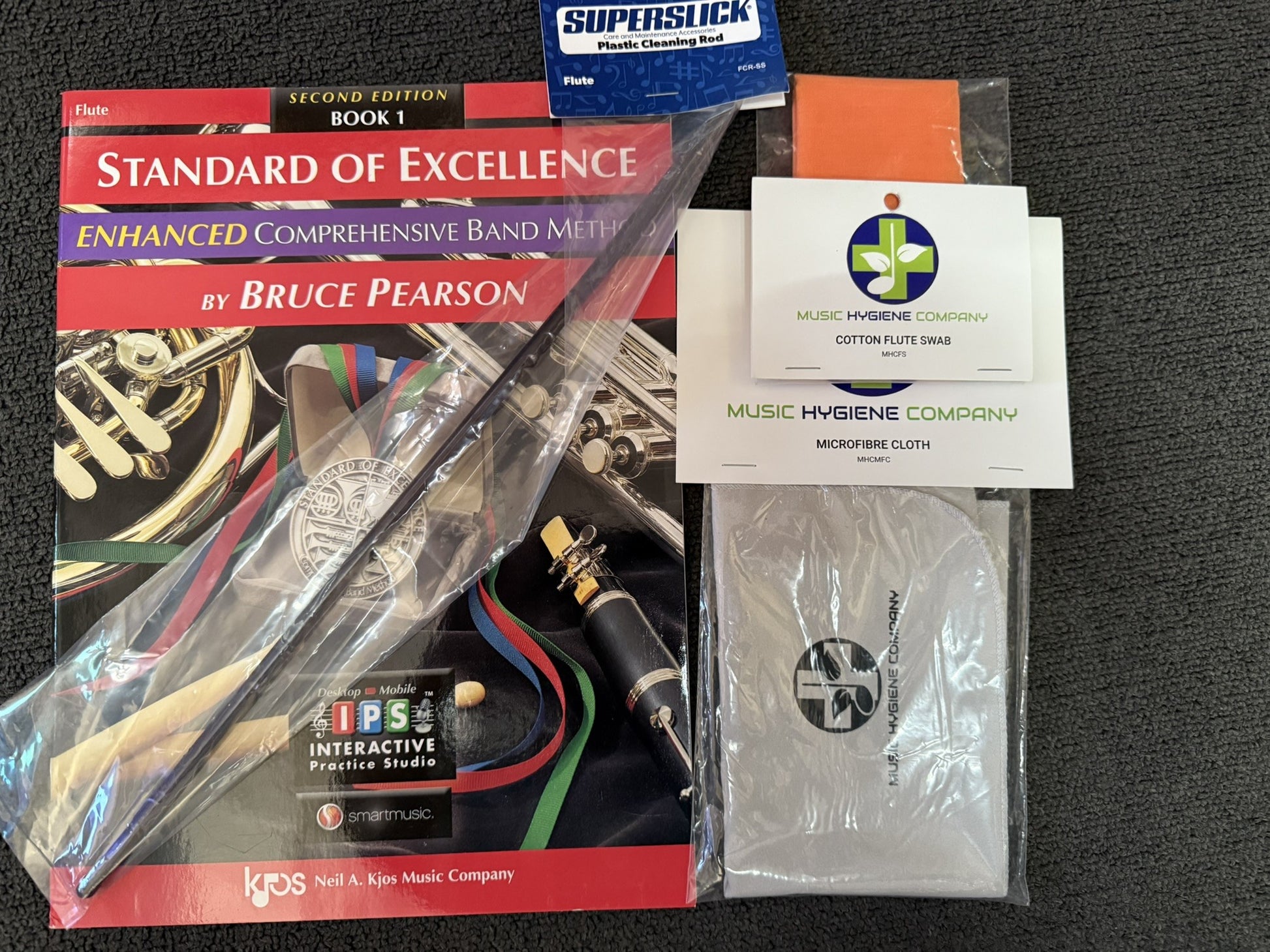 Flute student bundle with book, cleaning rod, cotton swab, and microfiber cloth.